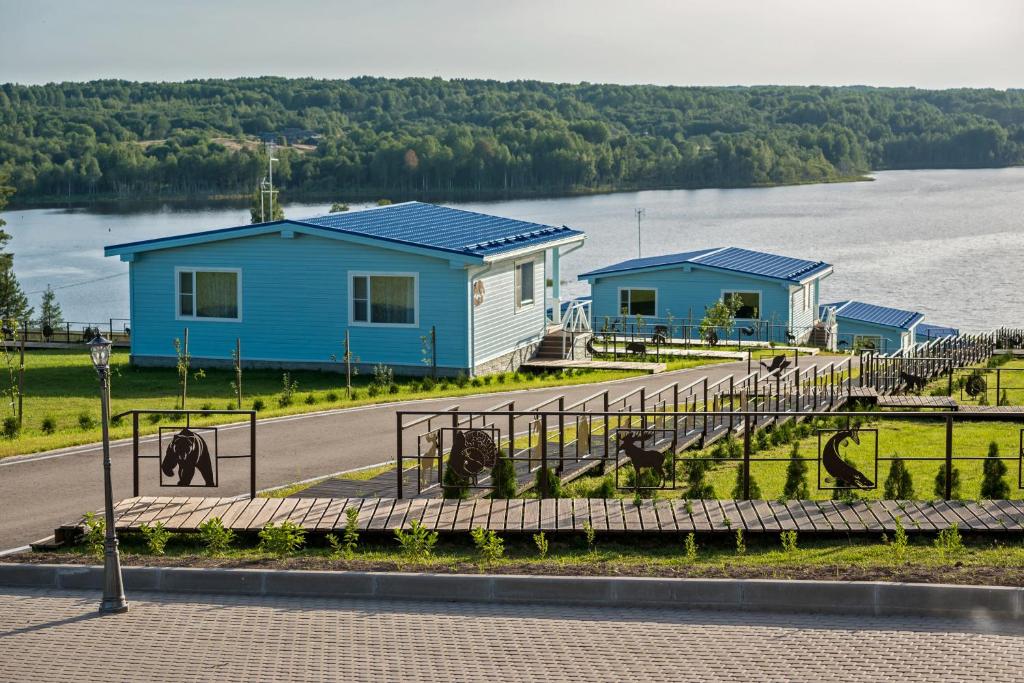 a blue building with animals in front of a road at Парк-отель Медвежья гора in Chudskaya