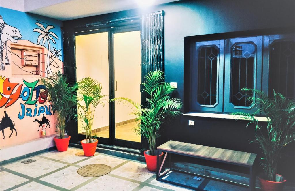 a room with potted plants and a bench at Hoztel Jaipur in Jaipur