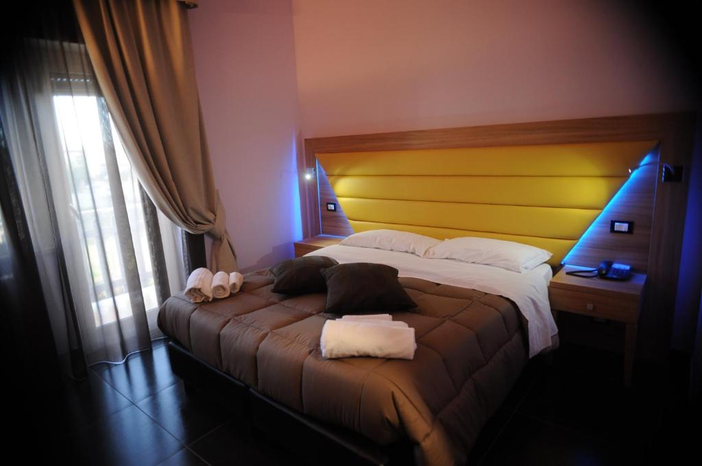 um quarto com uma cama grande e uma cabeceira amarela em Ostia Antica Suite B&B em Ostia Antica