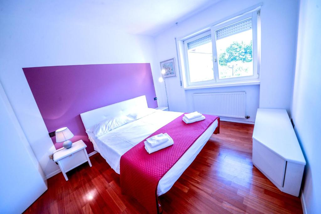 リーヴァ・デル・ガルダにあるThe Nestのベッドルーム1室(赤と白のベッド1台、窓付)