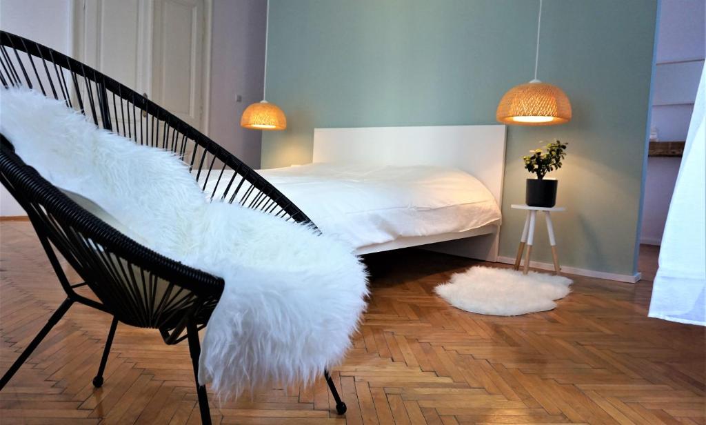 a bedroom with a bed and a chair with white fur at #Pobega heritage - self check-in in Timişoara