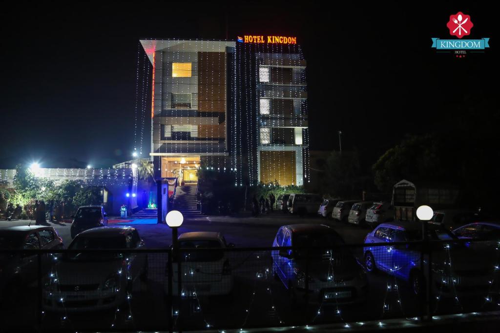 a hotel at night with a sign on it at Kingdom Hotel in Moga