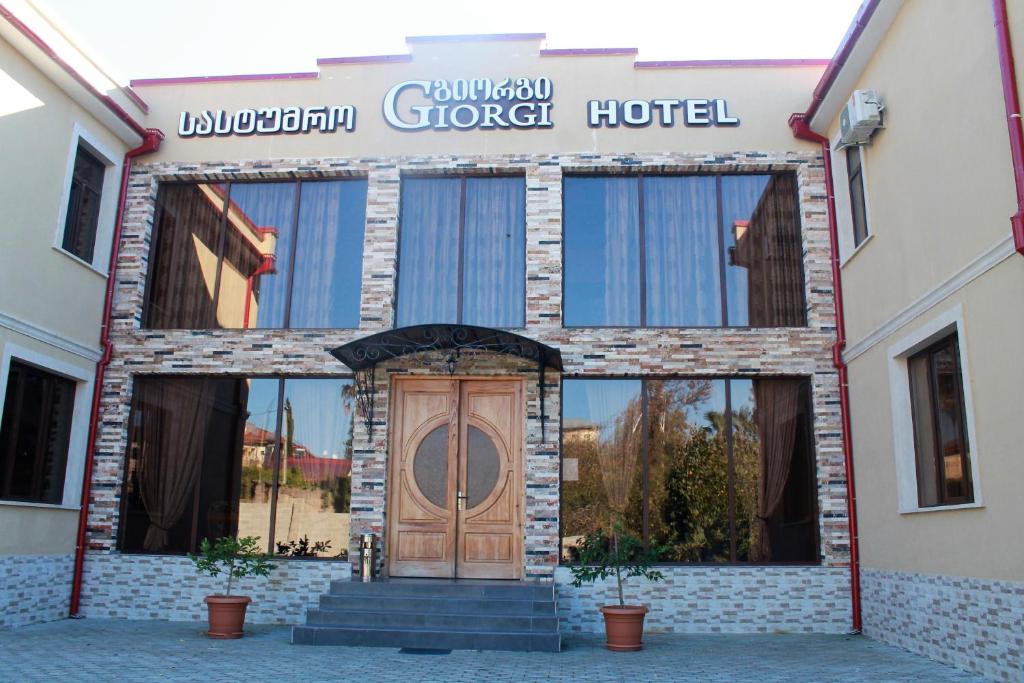 a building with a wooden door in front of it at Hotel Giorgi in Tsqaltubo
