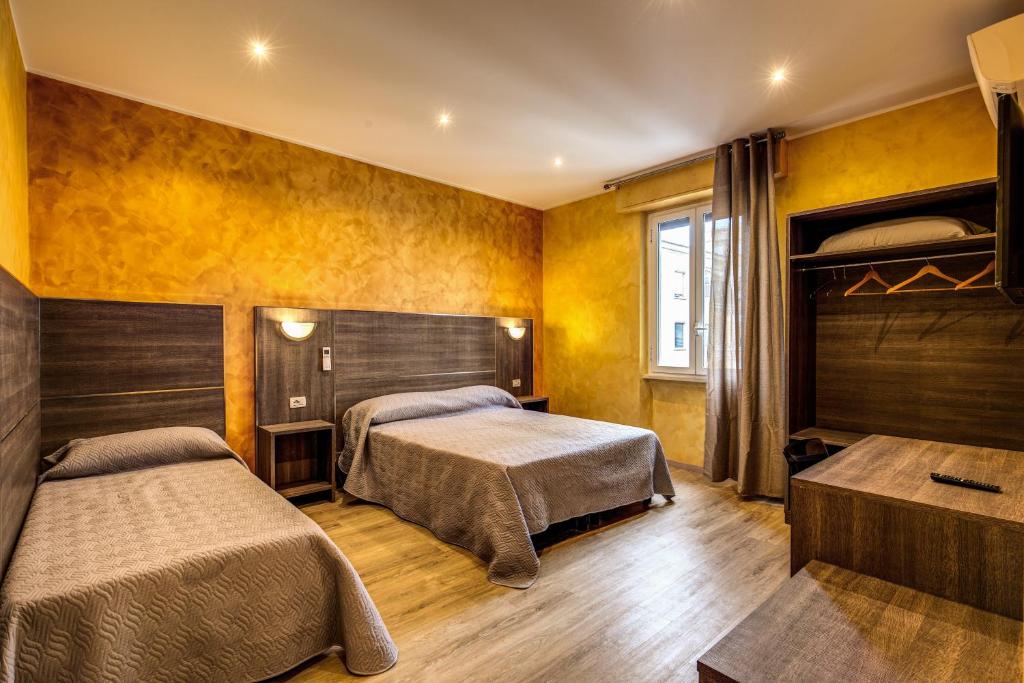 2 Betten in einem Zimmer mit gelben Wänden in der Unterkunft Hotel Osimar in Rom