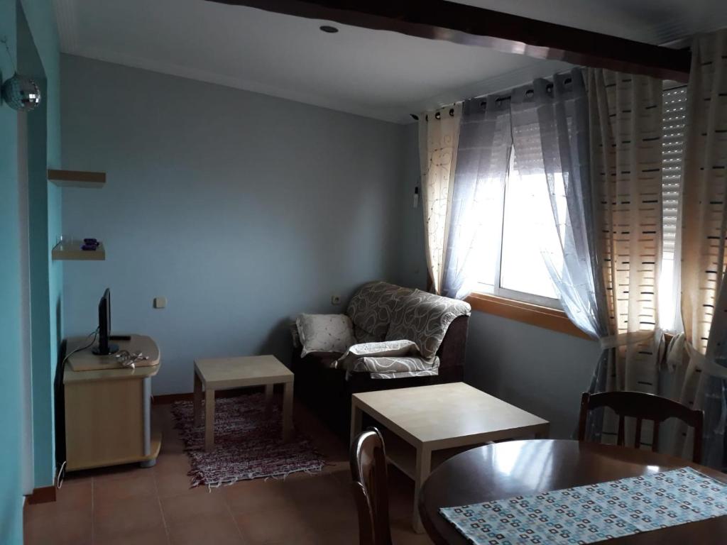 ビーゴにあるApartamento Duplex Vigoのリビングルーム(ソファ、テーブル付)、窓が備わります。