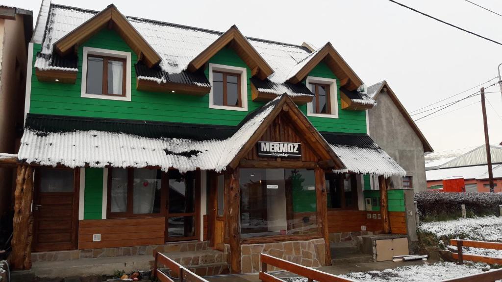 a green building with snow on the roof at MERMOZ in El Chalten