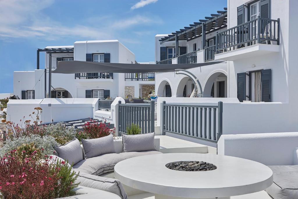 a patio with a table and chairs and a building at Parian Boutique Hotel in Naousa
