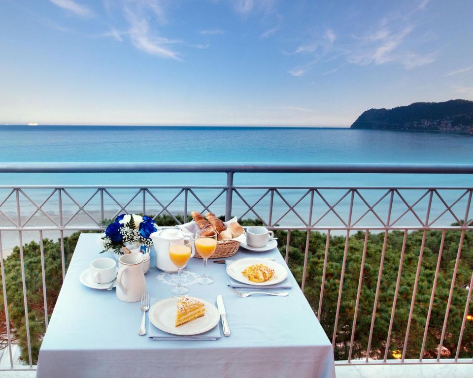 a table with food and drinks and a view of the ocean at Grand Hotel Spiaggia in Alassio