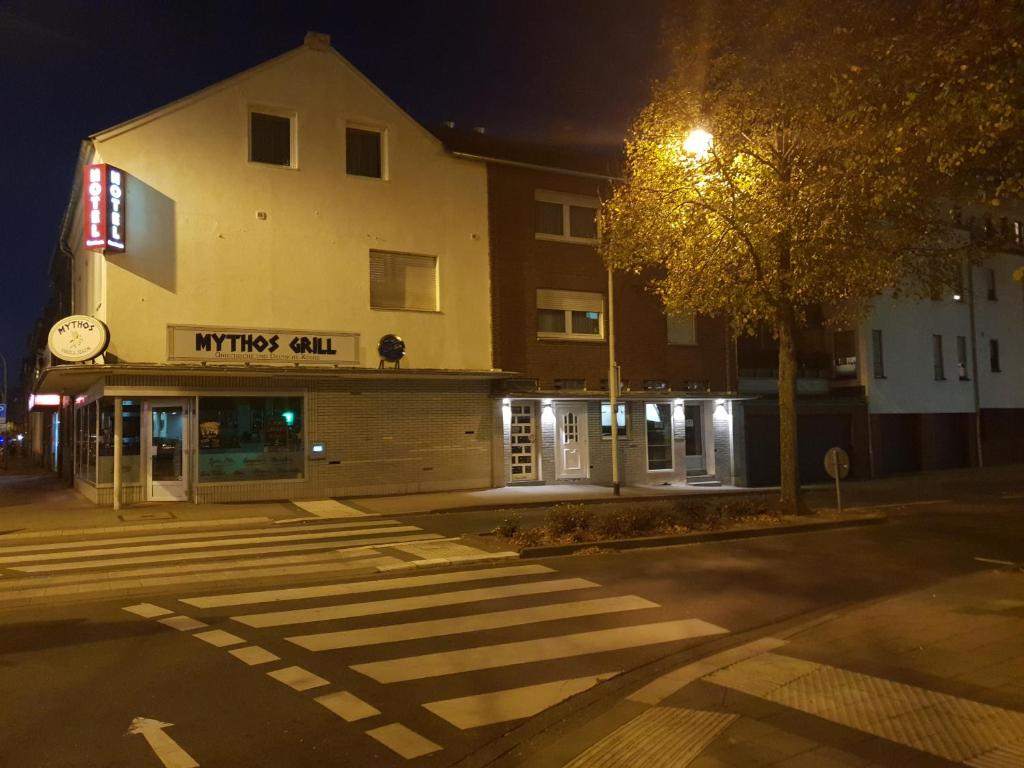 an empty street in front of a building at night at Hotel Zentrum in Grevenbroich