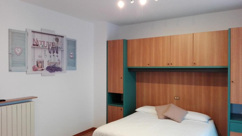 Schlafzimmer mit einem Bett und einem Kopfteil aus Holz in der Unterkunft Sweet Home Casa Vacanze "La Terrazza" in Rovetta