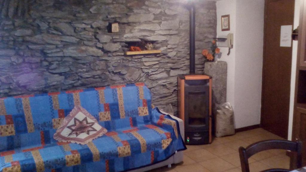 カンポドルチーノにあるCaldo Relaxのソファ付きの石壁の客室