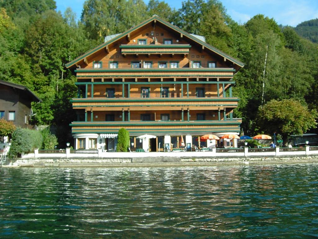 a large building next to a body of water at Seeappartement Kitzsteinhorn in Zell am See