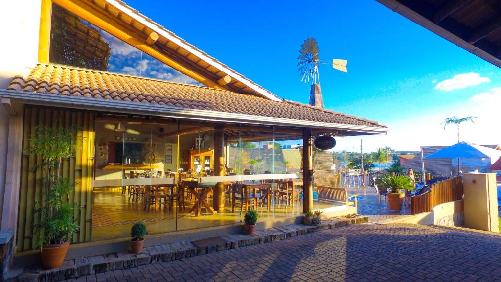 um restaurante com um pátio com mesas e cadeiras em Pousada Parador da Figueira em Lagoa da Prata