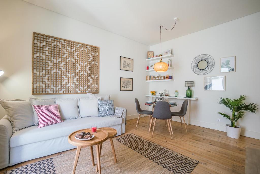 een woonkamer met een bank en een tafel bij Stylish Apartment near Av. Liberdade in Lissabon