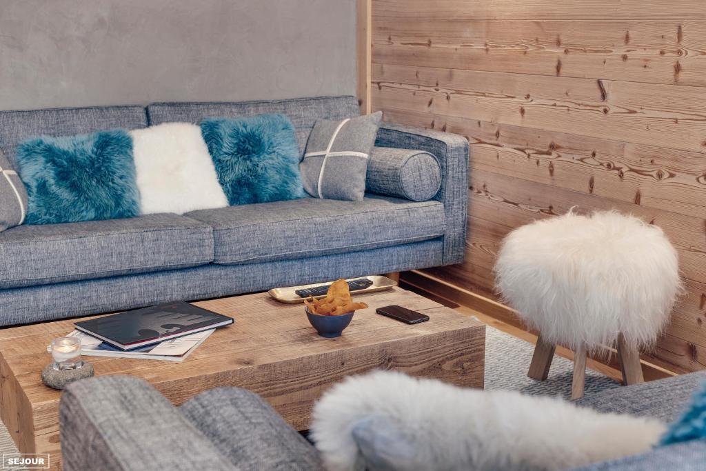 a living room with a couch and a table at Hôtel Avancher in Val-d'Isère