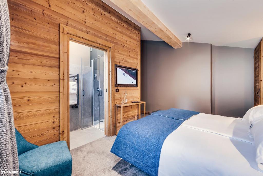 a bedroom with a bed and a sliding glass door at Hôtel Avancher in Val-d'Isère