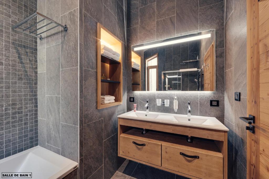 a bathroom with a sink and a shower and a mirror at Hôtel Avancher in Val-d'Isère