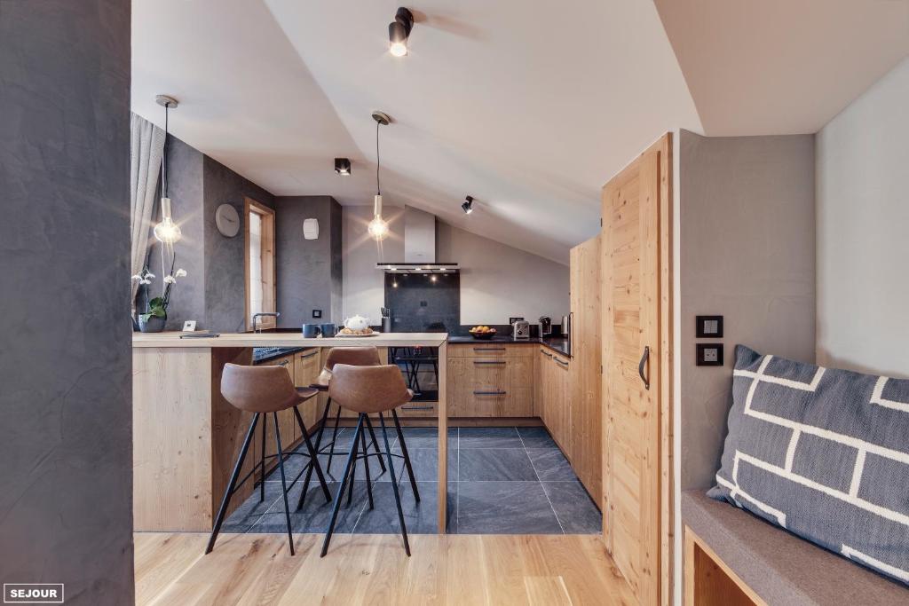 a kitchen with a counter and stools in a room at Hôtel Avancher in Val-d'Isère