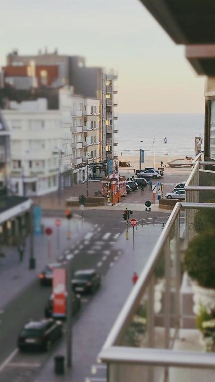 a view of a street with cars parked on the beach at Castel aan zee in Koksijde