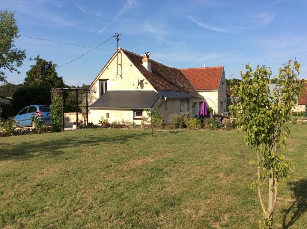 ein weißes Haus mit einem Garten mit einem Baum in der Unterkunft Papillon in Esves-le-Moutier