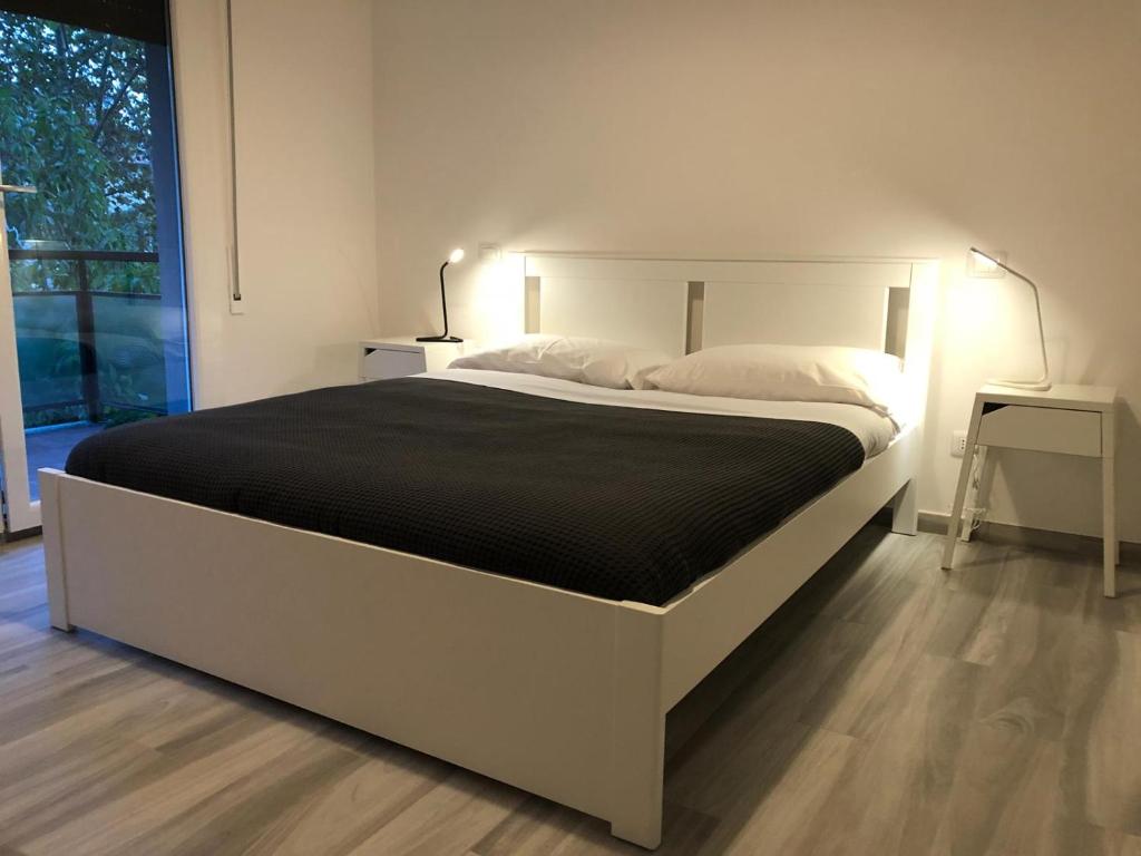 Four Rooms في بولونيا: سرير أبيض كبير في غرفة مع نافذة