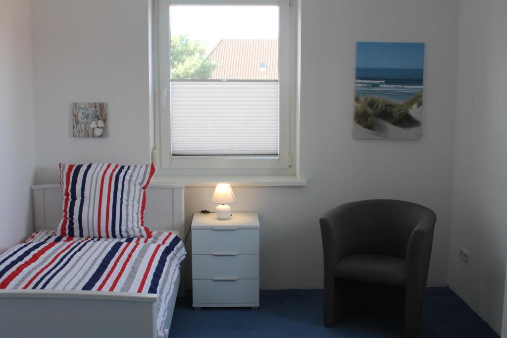 1 dormitorio con 1 cama, 1 silla y 1 ventana en 3 Zimmer Ferienwohnung - Woltorf, en Peine
