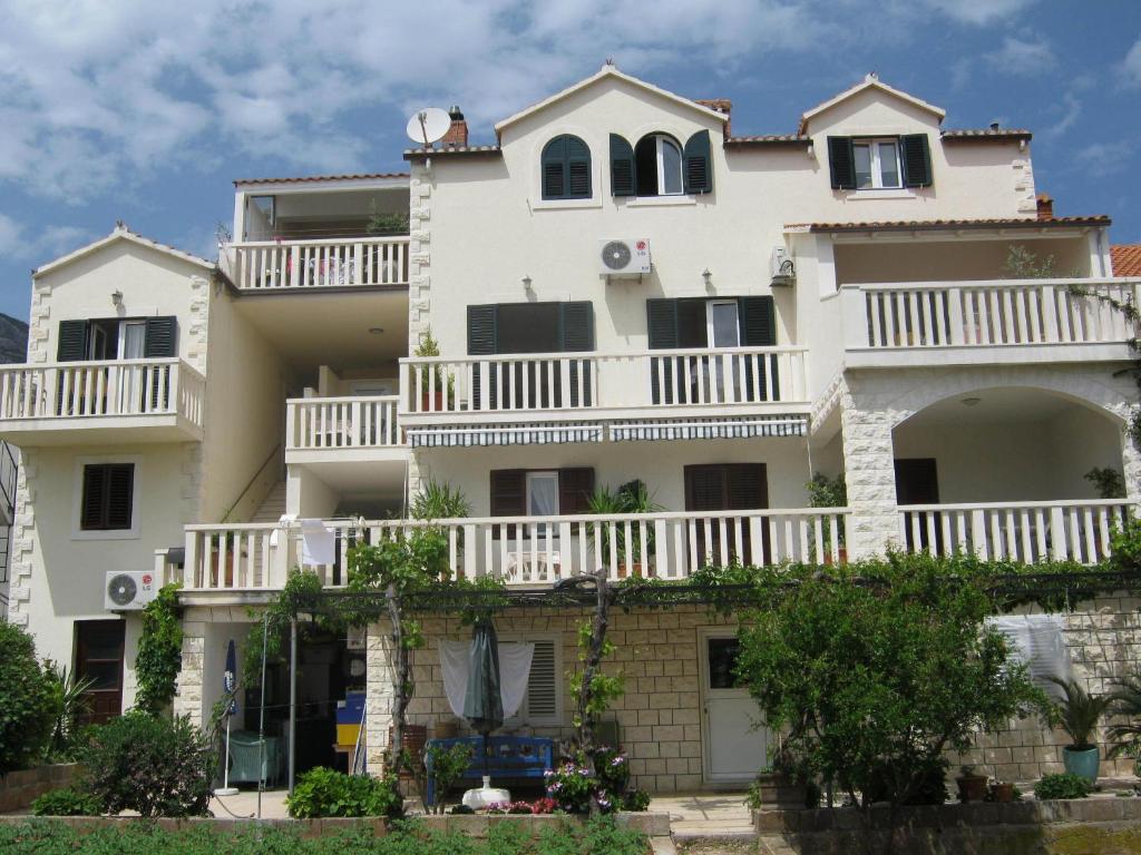 a large white house with white balconies at Apartments & Rooms Luna in Bol