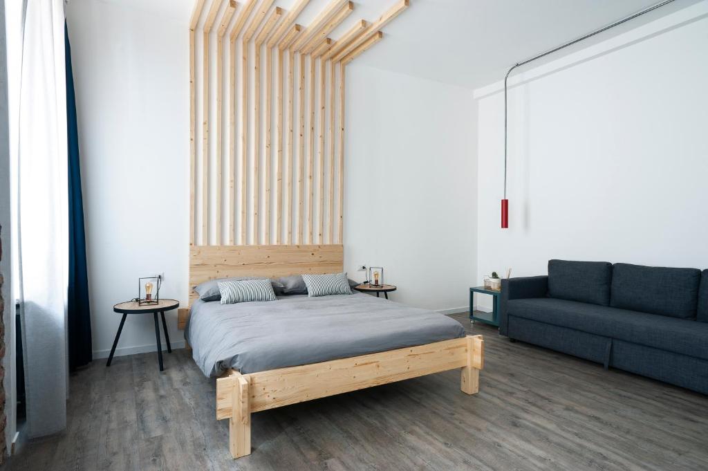 um quarto com uma cama de madeira e um sofá em Artisan Home em Bérgamo