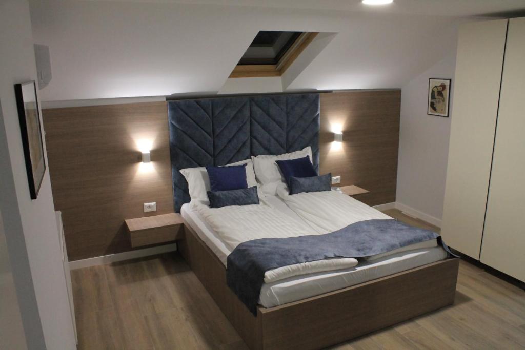 a bedroom with a large bed with blue pillows at Sleep Inn Prishtina in Pristina