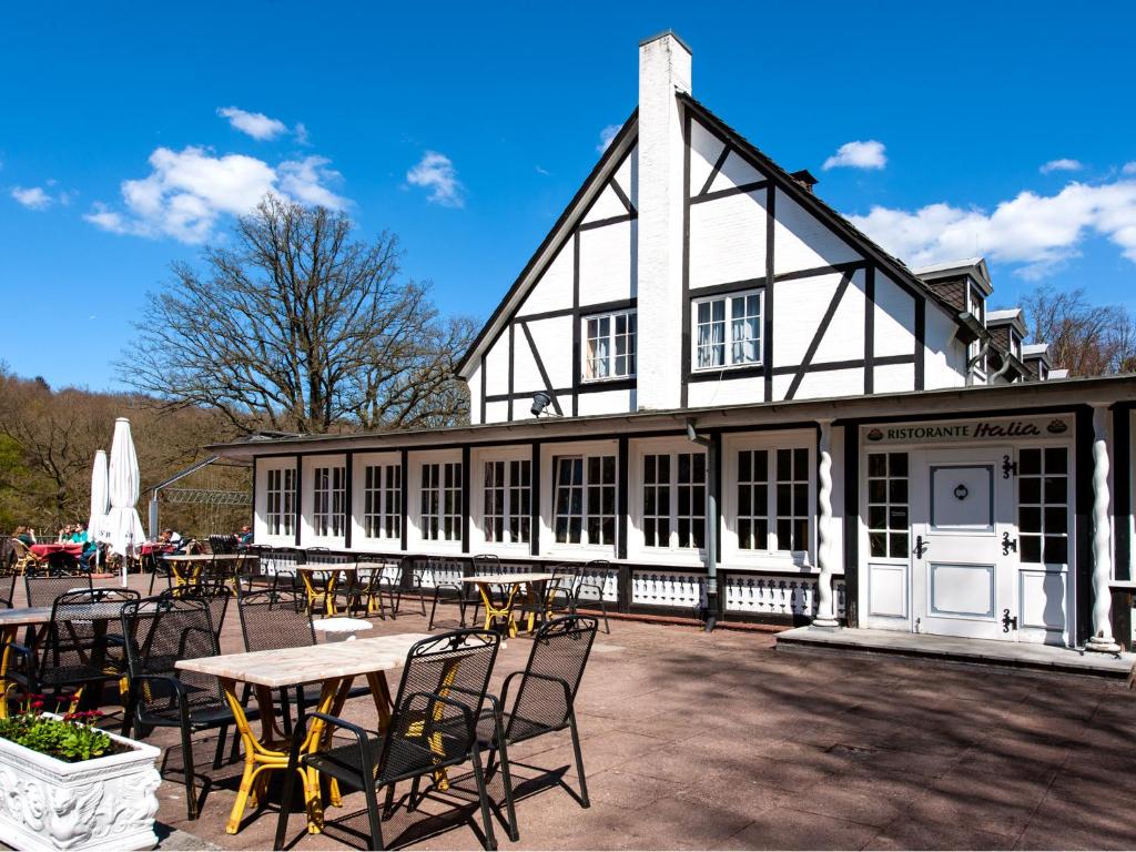 a building with a table and chairs in front of it at Hotel Italia in Aumühle