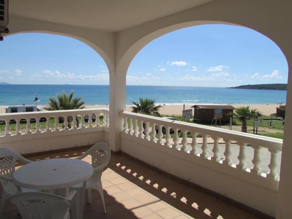 balcone con tavolo, sedie e vista sull'oceano di Apartamentos Miramar a Bolonia