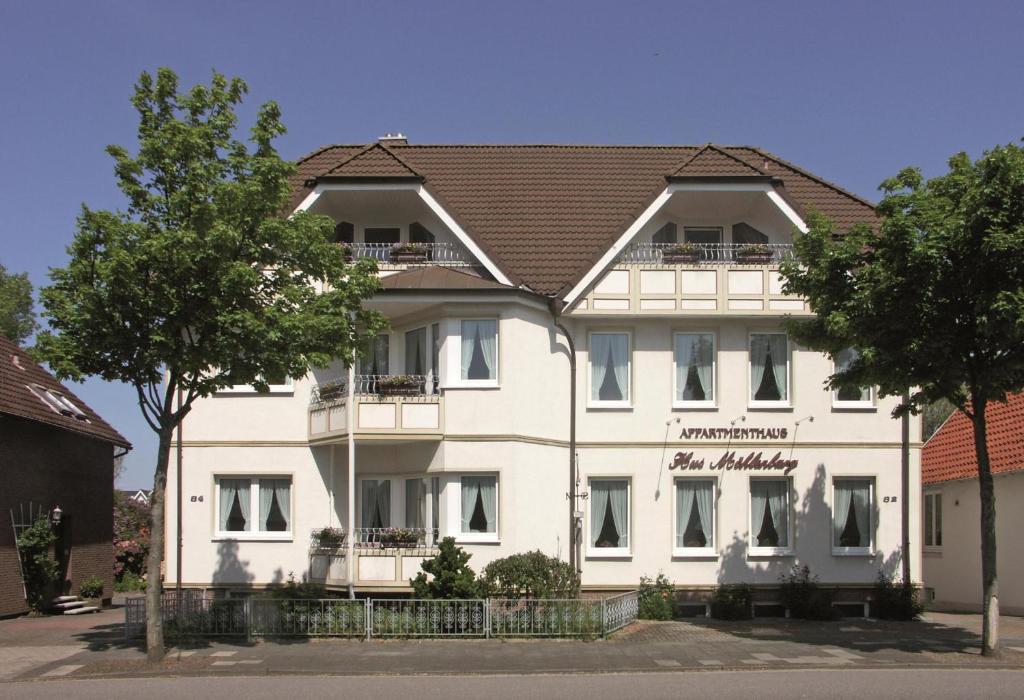 duży biały budynek z brązowym dachem w obiekcie Pension Appartementhaus Hus Möhlenbarg w mieście Cuxhaven