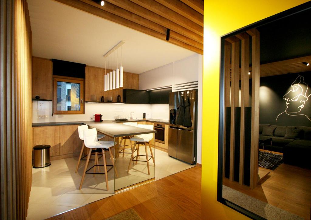 eine Küche und ein Wohnzimmer mit einem Tisch und Stühlen in der Unterkunft Apartment Gotham in Belgrad