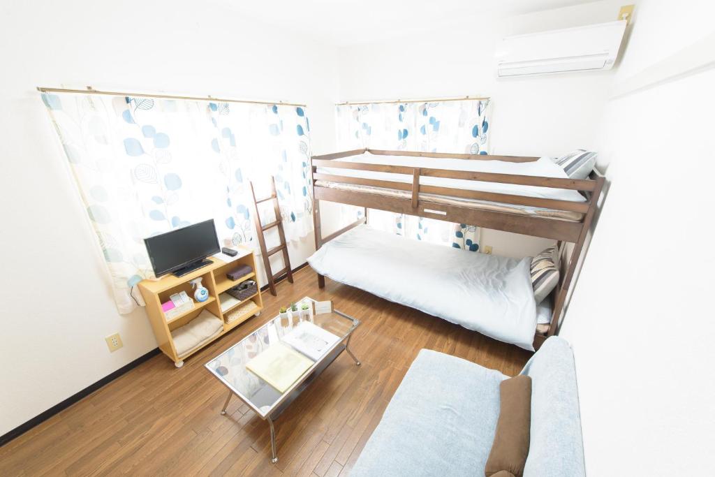 Cette petite chambre dispose de lits superposés et d'une télévision. dans l'établissement Cocostay Jarudan ココステイ ジャルダン, à Hiroshima