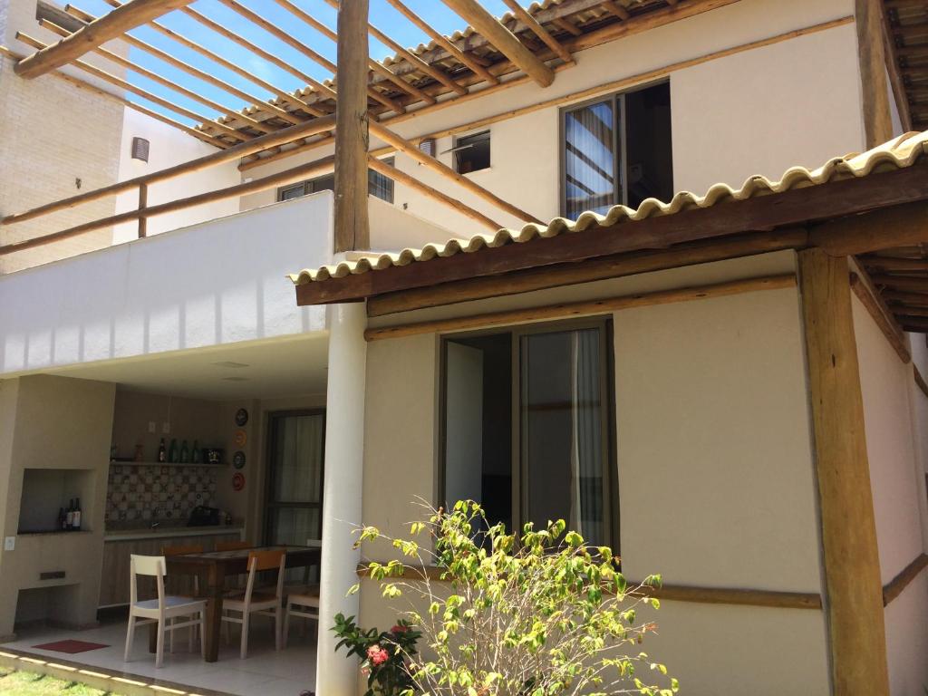 an external view of a house with a pergola at Village Duplex Confortável e Acolhedor junto a Natureza - Condomínio Reserva das Ilhas in Itacimirim