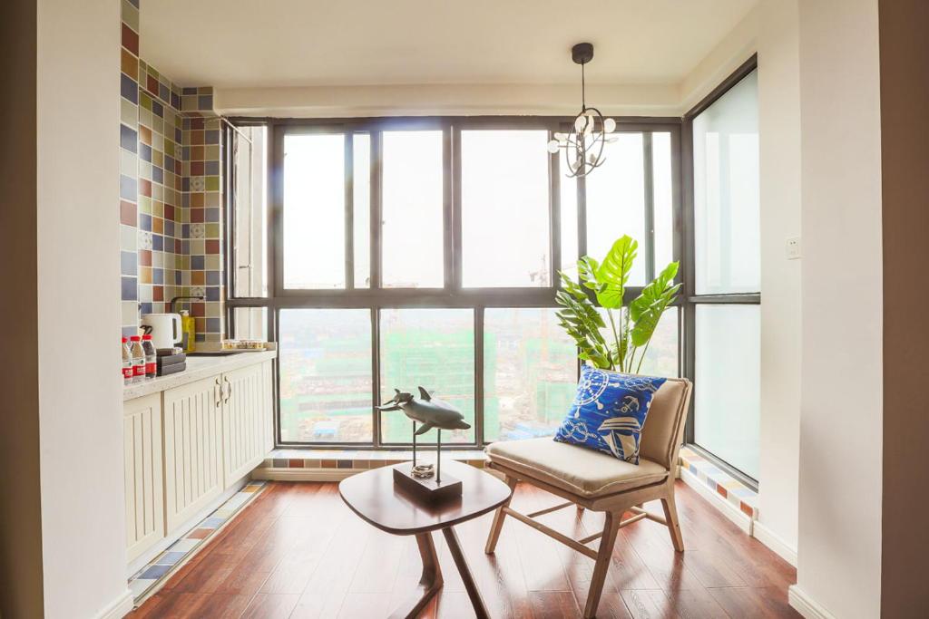 uma sala de estar com uma cadeira, uma mesa e uma janela em Chengdu Dujiangyan·DuJiangYan· Locals Apartment 00166900 em Zhongxing