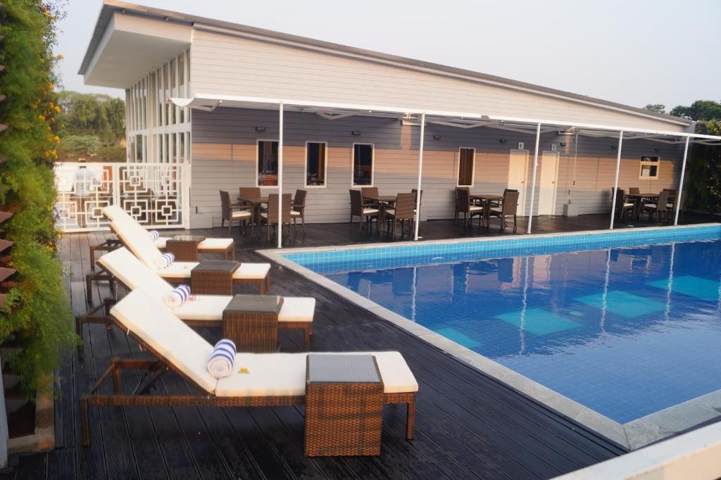 a swimming pool with lounge chairs next to a building at Bigstay in Tada