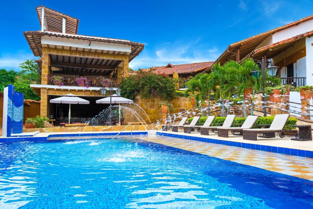 a swimming pool with a water fountain at Hotel Hicasua y Centro de Convenciones in Barichara