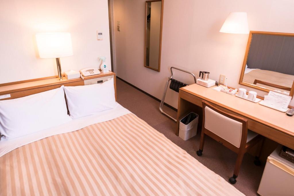 Postel nebo postele na pokoji v ubytování Hashimoto Park Hotel