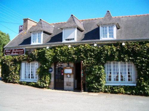 a building covered in ivy on a street at Hotel Restaurant Bocher in Ploubazlanec