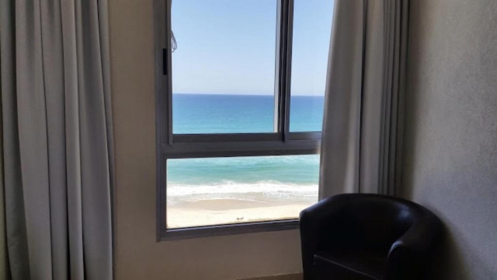 um quarto com uma janela com vista para o oceano em Sea View Deluxe em Bat Yam