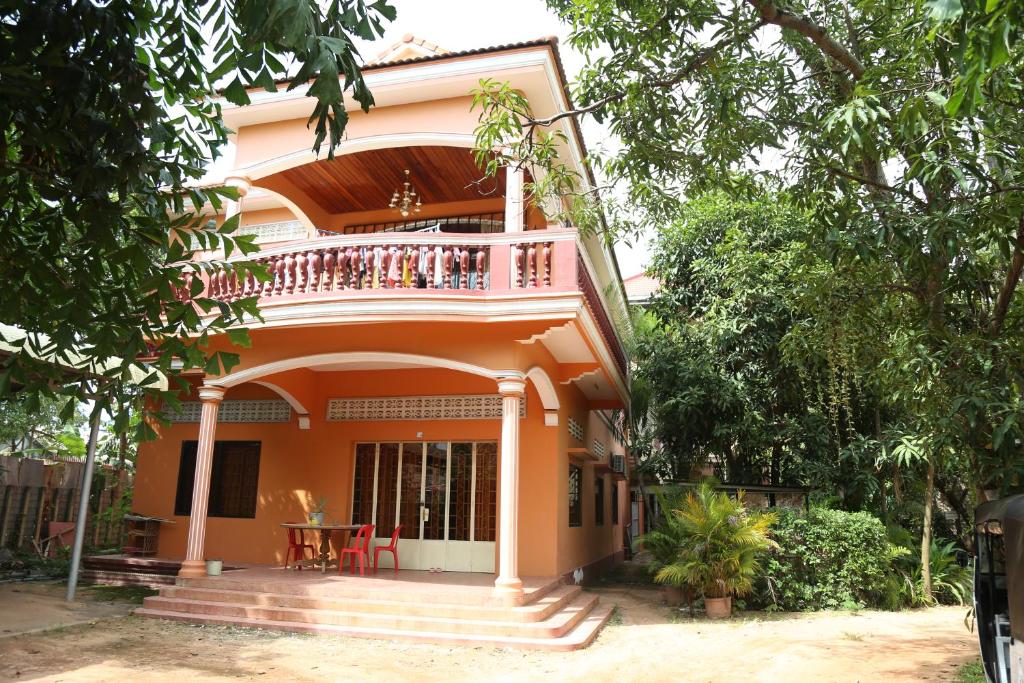 a house with a balcony and a table on it at Panhanita Apartment and Villa in Siem Reap