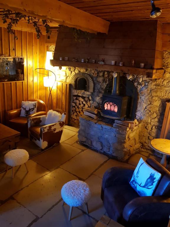 una sala de estar con chimenea de piedra en una casa en Lodge Hotel Les Rousses en Les Rousses