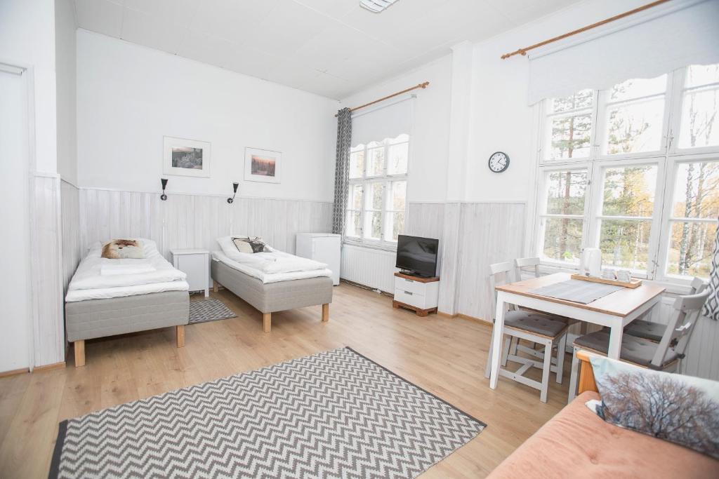 a white living room with a table and a couch at Guesthouse Koli Freetime in Ahmovaara