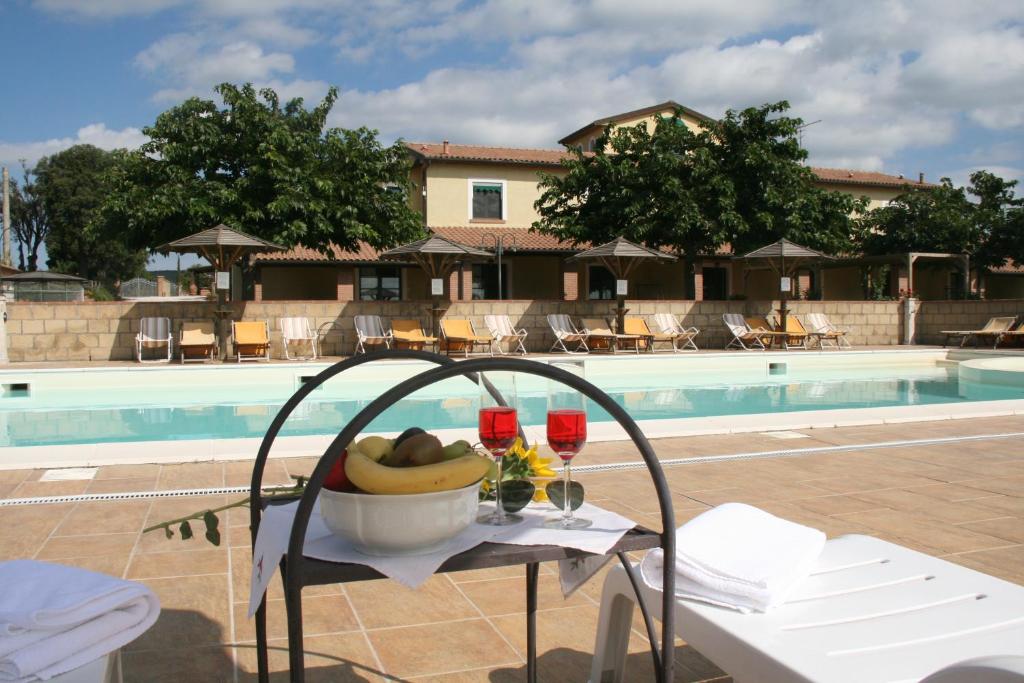 a table with a bowl of bananas on it next to a pool at Agriresidence Debbiare in Riparbella