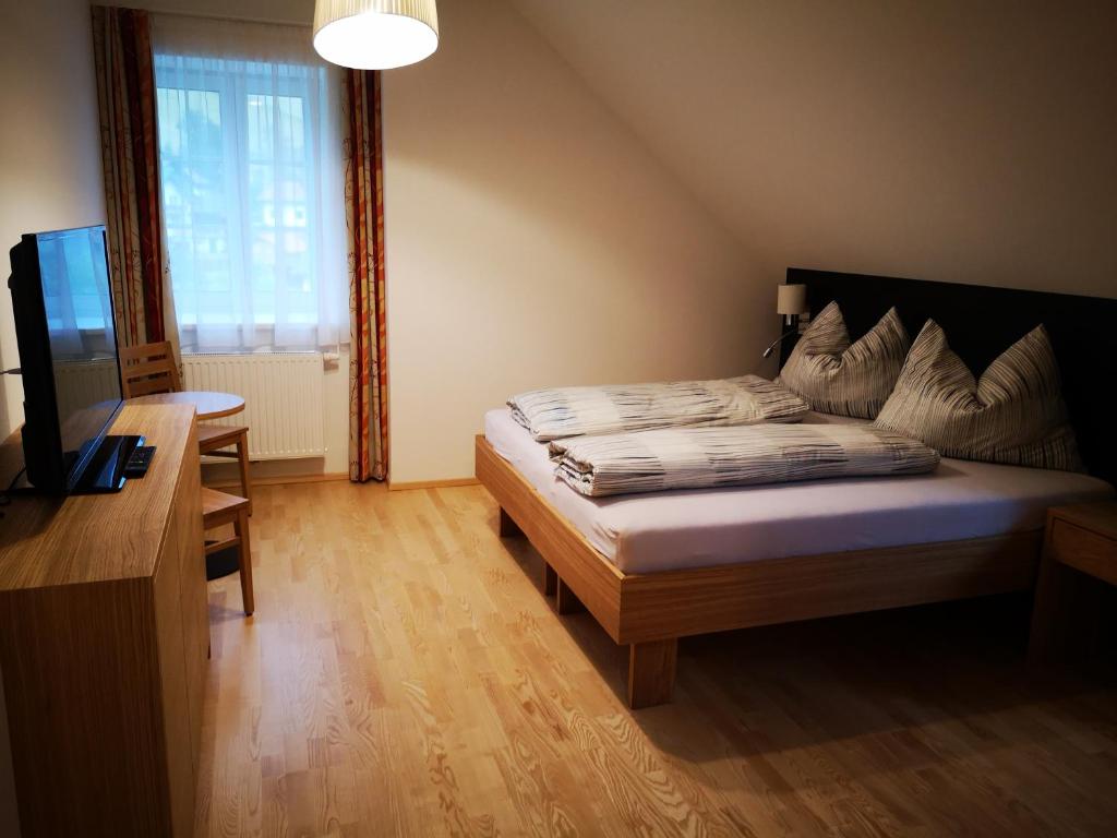 a bedroom with a bed and a desk and a television at Altenbergerhof in Neuberg an der Mürz