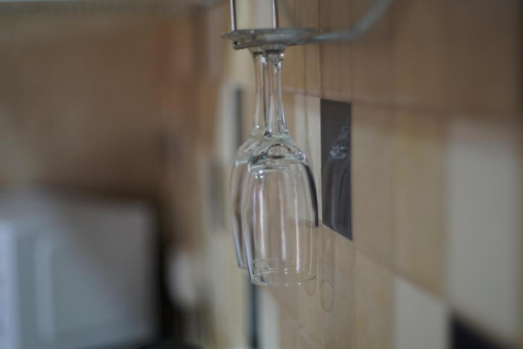 szklana butelka wisząca z kranu na ścianie w obiekcie Milo Apart Hotel w mieście Karaganda