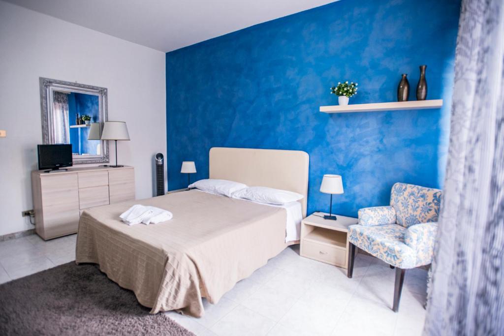 sypialnia z łóżkiem i niebieską ścianą w obiekcie Sant'Antonio Garden Rooms Apartments w mieście Nicolosi