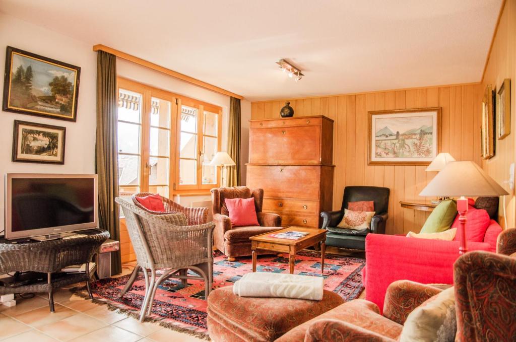 ein Wohnzimmer mit Möbeln und einem Flachbild-TV in der Unterkunft Apartment Bärhag - GRIWA RENT AG in Grindelwald