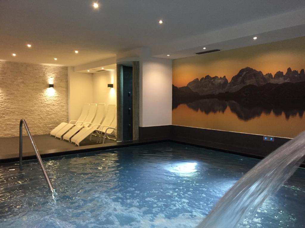 uma piscina num quarto de hotel com um spa em Hotel Ariston ***S em Madonna di Campiglio
